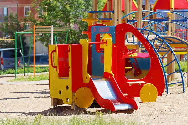 슬라이드와 놀이터에서 사다리 나무 색된 장난감 자동차 — 스톡 사진