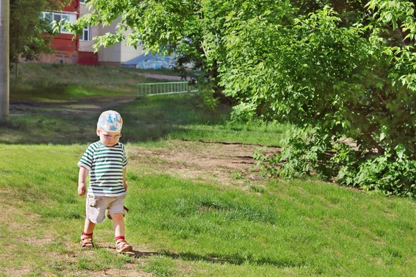 Pequeno menino bonito em óculos e caminhadas de t-shirt listrada — Fotografia de Stock