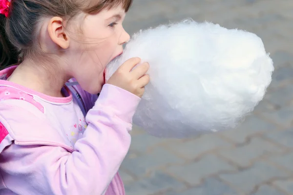 Trochę piękna dziewczyna w różowym zjada cotton candy odkryty — Zdjęcie stockowe