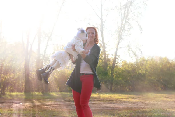 Счастливая молодая мать играет со своей маленькой дочкой — стоковое фото