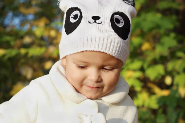 Close up portrait of beautiful little girl in hat near yellow tr — Stock Photo, Image