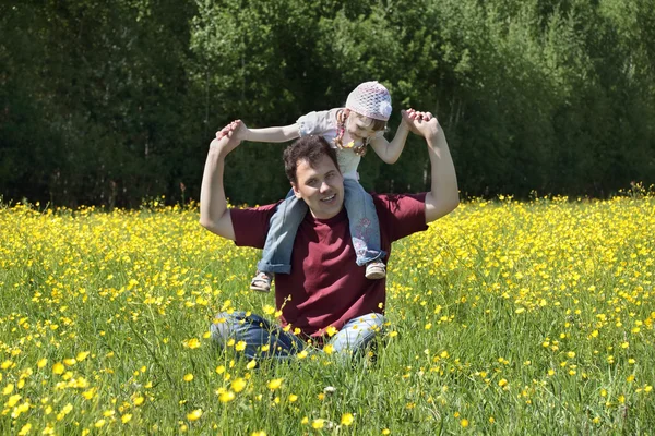 Felice padre gioca tiene la figlia sulle spalle tra il giallo — Foto Stock