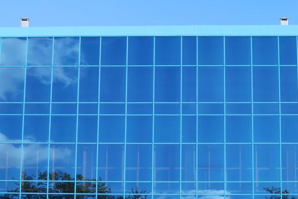 Parte de un edificio moderno con ventanas azules con reflejo — Foto de Stock