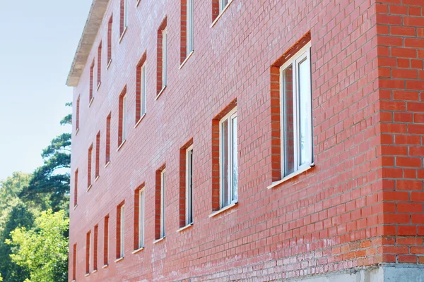 Część ściany z czerwonej cegły z okien budynku mieszkalnego — Zdjęcie stockowe