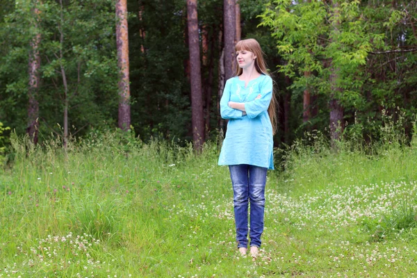 Pretty woman in blue stands in forest and smiles at summer day — Stock Photo, Image