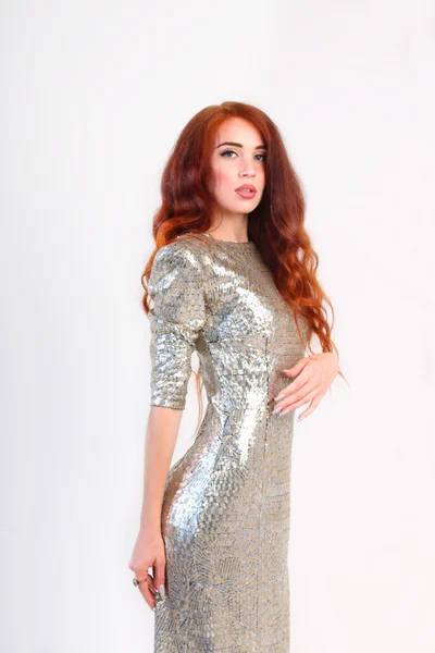赤い髪と光沢のある銀のドレス立っている美しい少女 — ストック写真