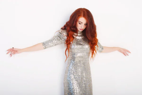 Beautiful young girl with red hair and shiny silver dress standi — Stock Photo, Image