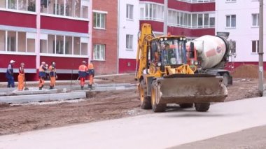 Perm, Rusya Federasyonu - 25 Mayıs 2015: Beton Mikser ve traktör perma bitki silikat panelleri inşaat sitesinde çalışmak