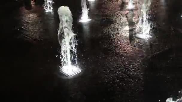 Прекрасний фонтан з кольоровим освітленням і натовпом вночі — стокове відео