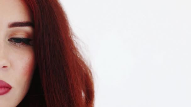 La mitad de la cara de la mujer parpadeante con el pelo rojo. De cerca. — Vídeos de Stock