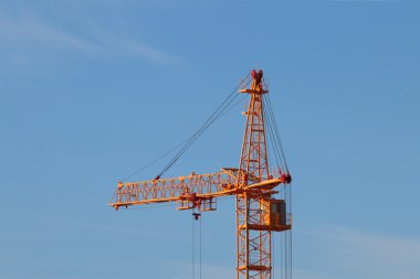Tall yellow stationary hoist construction site and blue sky