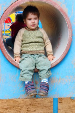 Yakışıklı küçük çocuk bahçesi kanalda yaz gününde oturuyor