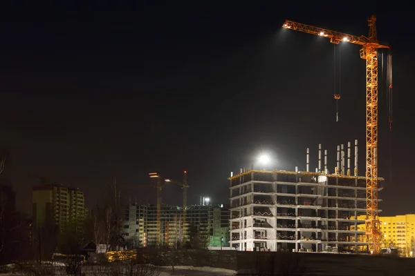 Hoog kranen en bakstenen gebouwen in aanbouw — Stockfoto