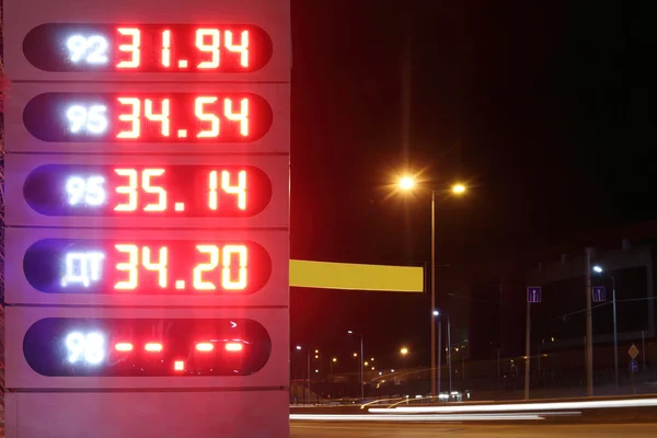 Preços iluminados da gasolina no posto de gasolina na noite de inverno — Fotografia de Stock