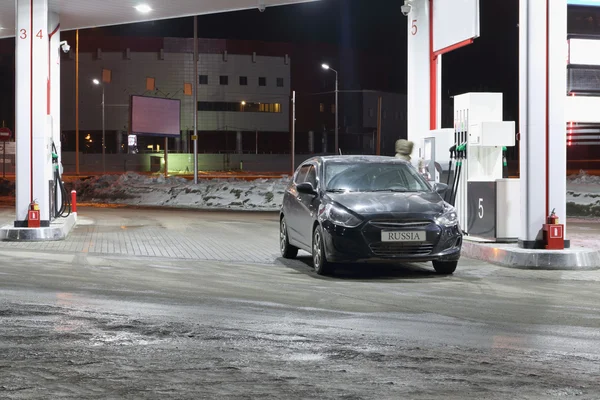 Dauerwelle, Russland - 6. März 2015: Auto und Fahrer an Tankstelle — Stockfoto