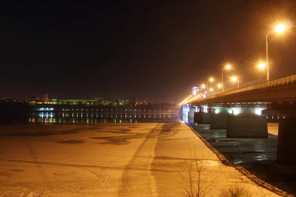 Мост с подсветкой и фонарями и подсветкой набережной — стоковое фото