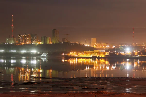 Edifícios e torre de tv com iluminação e reflexão no rio — Fotografia de Stock