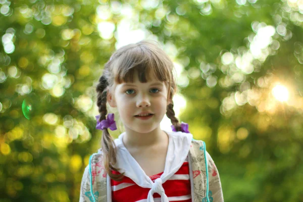 Ritratto di bella sorridente bambina con trecce all'aperto — Foto Stock