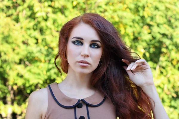 Retrato hermosa joven con maquillaje y pelo largo rojo — Foto de Stock