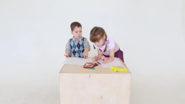 Kleine Mädchen und Jungen malen im Atelier mit Buntstiften auf Papierbögen — Stockvideo