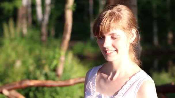 Hermosa mujer sonriente con luz solar brillante en la cara se esconde en la sombra — Vídeo de stock