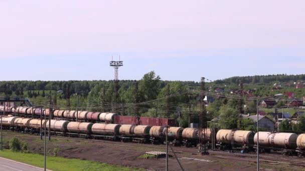 Tren con tanques cerca de bosque y pueblo en verano día soleado — Vídeo de stock