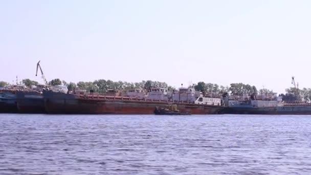 Boat floats on river near largest ships in summer sunny day — Stock Video