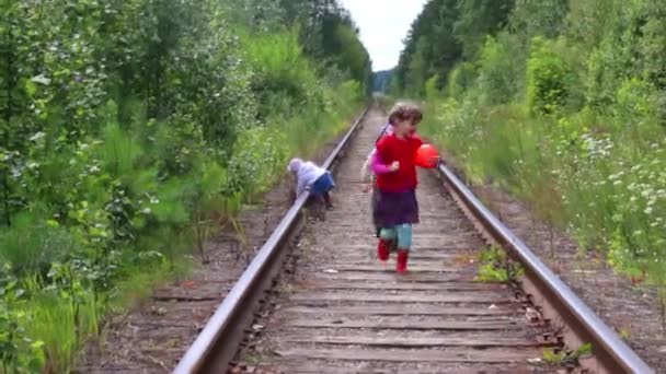 Drie kinderen spelen op de spoorlijn in bos op zomerdag — Stockvideo