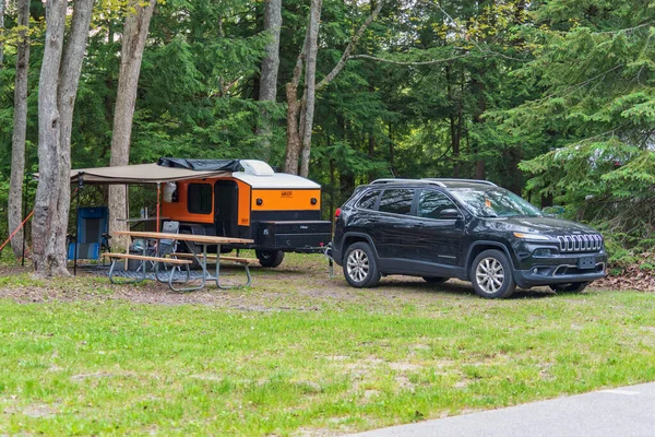Small teardrop travel trailer parked at a state campground site — Stock Photo, Image