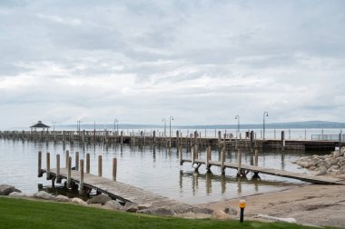 Ahşap rıhtımlar ve rıhtımlar bulutlu bir gökyüzünün altında sakin bir bölmeye uzanıyor.