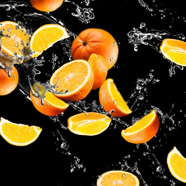 Oranje vruchten en spatten water — Stockfoto