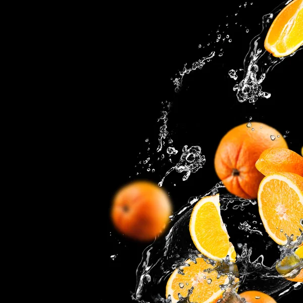 Oranje vruchten en spatten water — Stockfoto