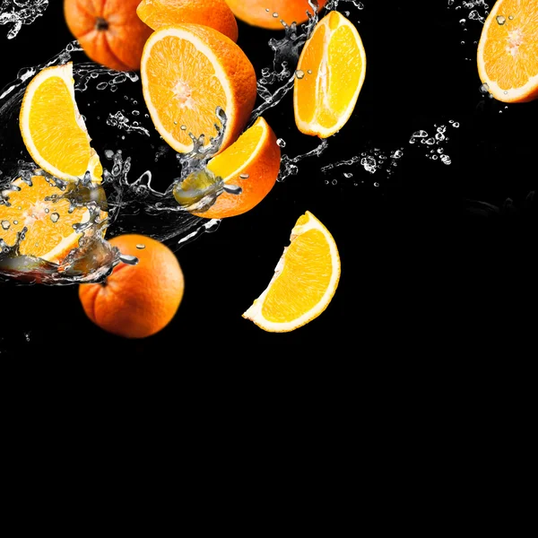 Frutas de laranja e água salpicante — Fotografia de Stock