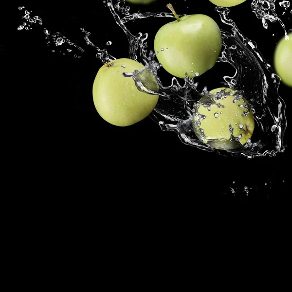 Яблоки фрукты и брызги воды — стоковое фото
