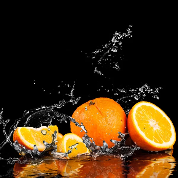 Oranje vruchten en spatten water — Stockfoto