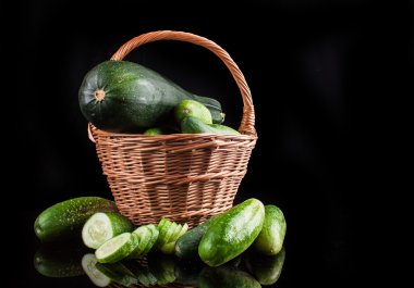 salatalık ve kabak siyah bir zemin üzerine ahşap bir tekerlek