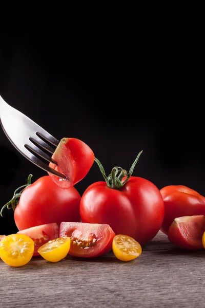 Tomates sobre um fundo preto — Fotografia de Stock