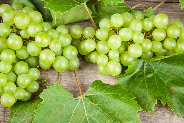 Uvas, vinho branco em uma mesa de madeira — Fotografia de Stock