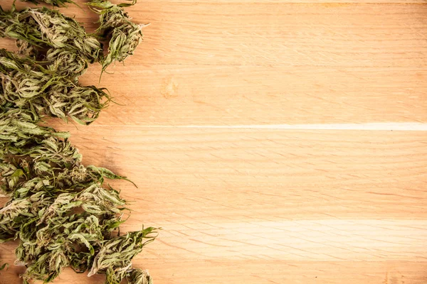 Big canabis marijuana plant detail on wood table — Stock Photo, Image