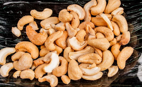 Cashew-nötter på en svart bakgrund — Stockfoto