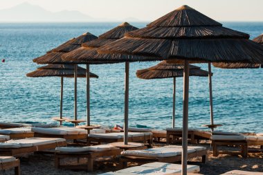 Reed şemsiye şezlong bir plajda denizin