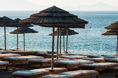 Reed şemsiye şezlong bir plajda denizin