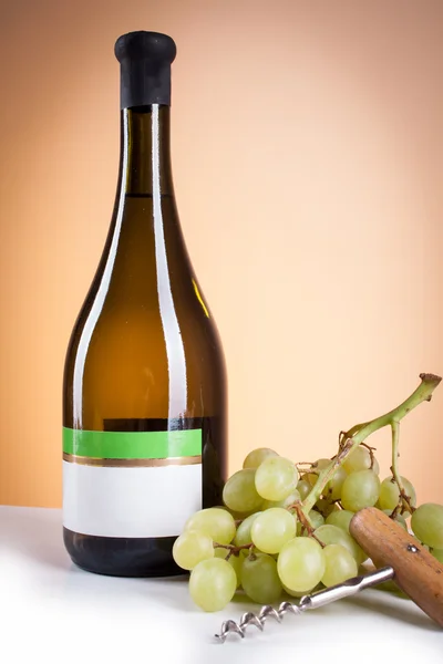 White wine in bottle and glass and a bunch of white grapes — Stock Photo, Image