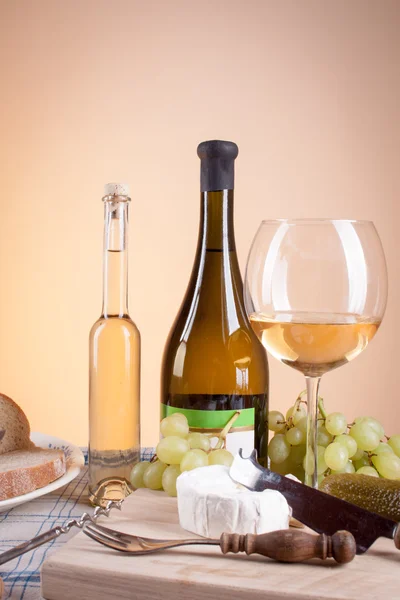 White wine in bottle and glass and a bunch of white grapes — Stock Photo, Image
