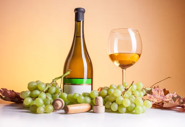 White wine in bottle and glass and a bunch of white grapes — Stock Photo, Image