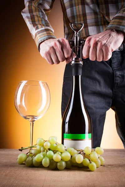 Bottle of white wine and grapes on a wooden table — Stock Photo, Image