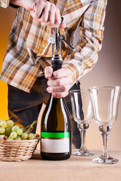 Bottle of white wine and grapes on a wooden table — Stock Photo, Image