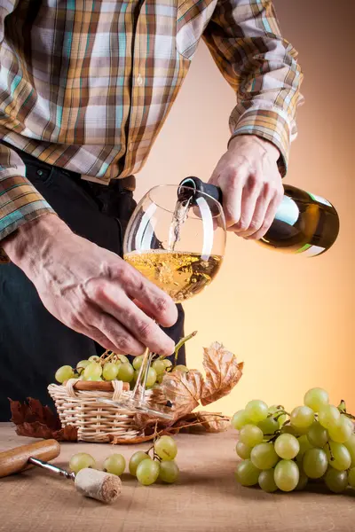 Bottle of white wine and grapes on a wooden table — Stock Photo, Image