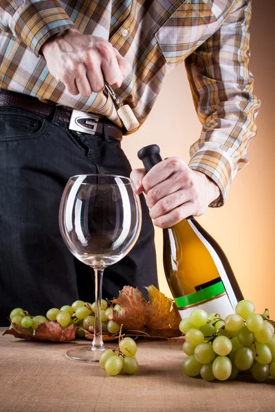 Bottle of white wine and grapes on a wooden table — Stock Photo, Image