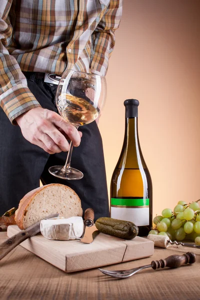 Bottle of white wine and grapes on a wooden table — Stock Photo, Image